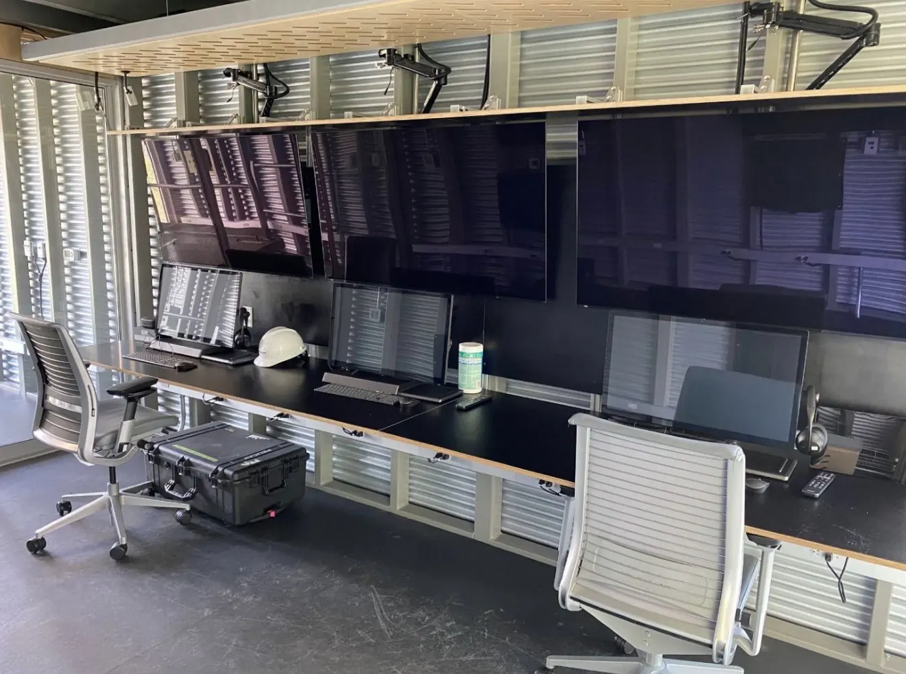 Pod interior with multi-screen command stations and chairs